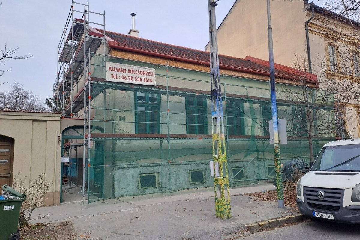 Városi épület homlokzati állványozása védőhálóval, biztonságos felújítási munkákhoz